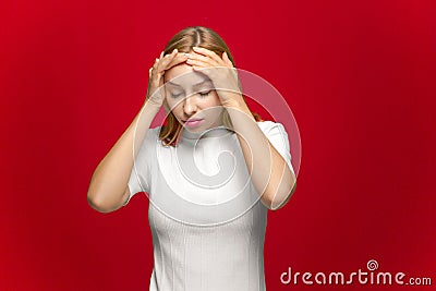 Headache. Tired young girl feeling unhealthy, suffer unbearable migraine flu symptom on red studio background Stock Photo