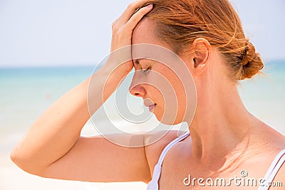 Headache woman on sunny beach. Woman with sunstroke. Hot sun danger. Health problem on holiday. Stock Photo
