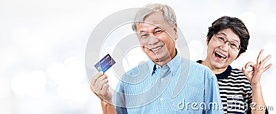 Header of happy asian cheerful senior couple, retirees or older parents smiling and showing credit card with satisfaction in Stock Photo