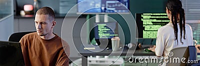 Header Image of Male Programmer Coding on Computer Working with Colleagues in Office Stock Photo