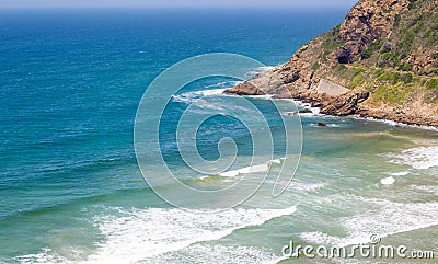 Headland jutting into the sea with railway tunnel and tracks next to bay Stock Photo