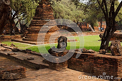 Headless Buddah statue between the old ruins of a temple Stock Photo