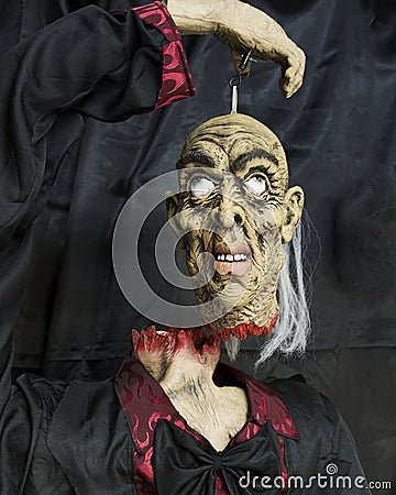 Headless butler holding his own head suspended Stock Photo