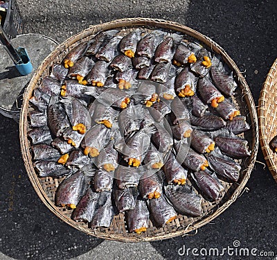 Headless dried fish called Pla Salit on round bamboo basket Stock Photo