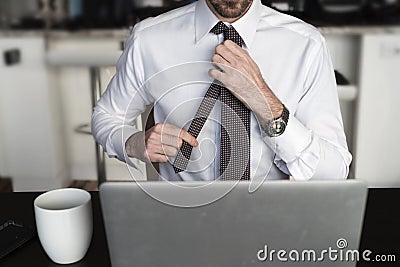 Headless man adjusting tie at desk Stock Photo