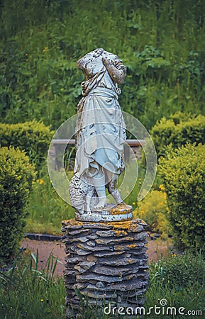 Headless statue of with a sheep in the garden Stock Photo