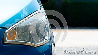 Headlights of bue car. with sunlight casting a radiant glow on the hood. Stock Photo