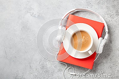 Headphones, book and cup of coffee on concrete surface Stock Photo