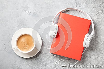 Headphones, book and cup of coffee on concrete surface Stock Photo