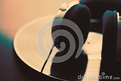 Headphones lying on vintage black vinyl long play record in vintage style with firm effect. Abstract blurred image for music Stock Photo