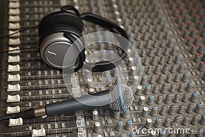 Headphones and microphone on old dirty sound mixer Stock Photo