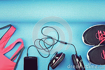 Headphones and sport accessories on blue yoga mat background. Stock Photo