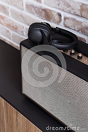 Headphones on stereo speaker on dark brown shelf Stock Photo