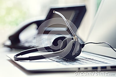 Headset headphones telephone and laptop in call center Stock Photo