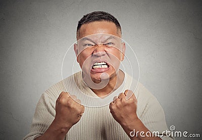 Headshot angry man with open mouth fist up in air aggressive screaming Stock Photo