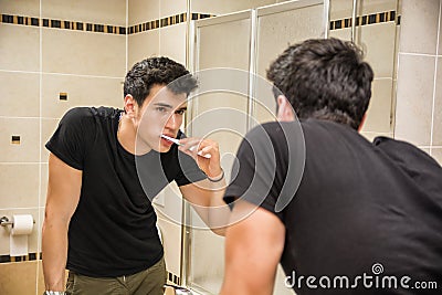 Headshot of attractive young man brushing teeth Stock Photo