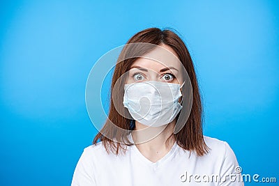 Surprised woman in aseptic mask. light blue background Stock Photo