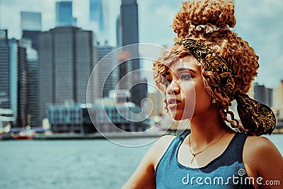 headshot beautiful young adult woman afro hairstyle with Manhattan New York City skyline in the background outdoors Stock Photo