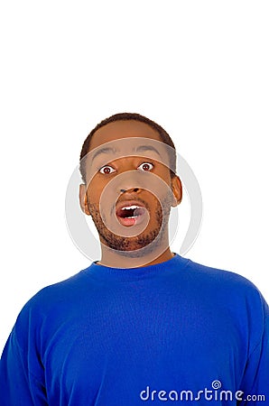 Headshot handsome man wearing strong blue colored t-shirt making surprised shocked facial expression, white studio Stock Photo