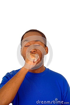 Headshot handsome man wearing strong blue colored t-shirt yawning and looking tired, white studio background Stock Photo