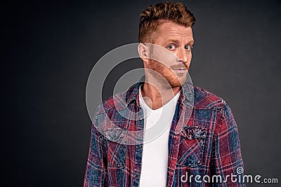 Headshot of intrigued good-looking ginger male with bristle in blue shirt turning at camera with impressed and curious expression Stock Photo