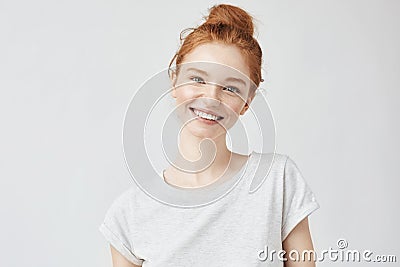 Headshot Portrait of happy ginger girl with freckles smiling looking at camera. White background. Stock Photo