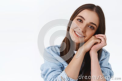 Headshot of tender and feminine dreamy coquettish woman in denim jacket, tilt head, clasp hands together near cheek Stock Photo