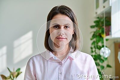 Headshot young smiling woman looking at camera in home interior Stock Photo