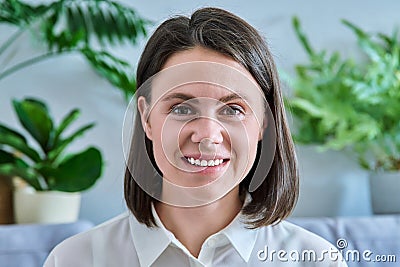 Headshot young smiling woman looking at camera in home interior Stock Photo