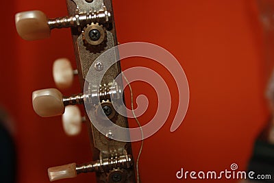 Headstock with mechanics of a classical guitar with orange background Stock Photo