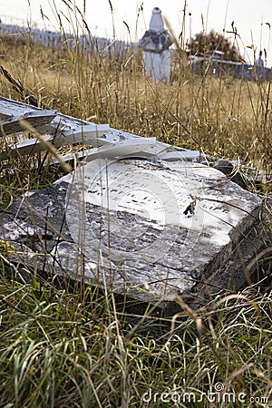 Headstone in tall weeds Stock Photo