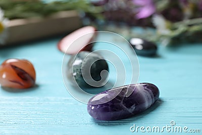 Healing gemstones on light blue wooden table Stock Photo