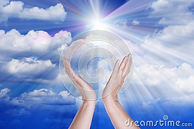 Healing hands in the sky with bright sunburst. Stock Photo