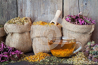 Healing herbs in hessian bags and healthy tea cup Stock Photo
