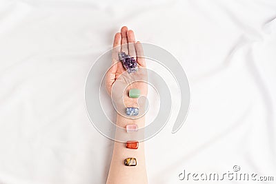 Healing reiki chakra crystals on woman's hands. Gemstones for wellbeing, meditation, relaxation Stock Photo