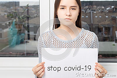 Health care concept. Girl holding a sheet with the words stop covid-19 Stock Photo