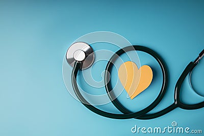 Health Care Concept. International World Heart Day. Paper Cut as Heart Shape with Stethoscope lay on Blue background Stock Photo