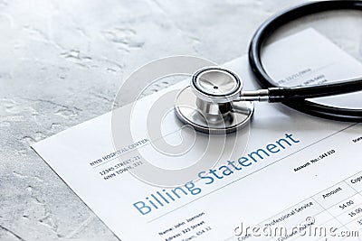 Health care costs with billing statement, stethoscope on stone table Stock Photo