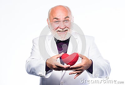 Health care. Preventing heart attack. Senior bald head bearded man holding red toy heart in hands. Healthy life. Mature Stock Photo