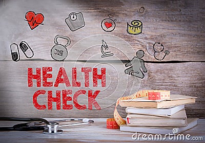 Health Check. Stack of books and a stethoscope on a wooden background Stock Photo