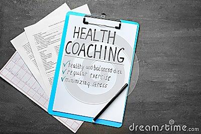 Health coaching written on sheet of paper with medical documents on grey background Stock Photo