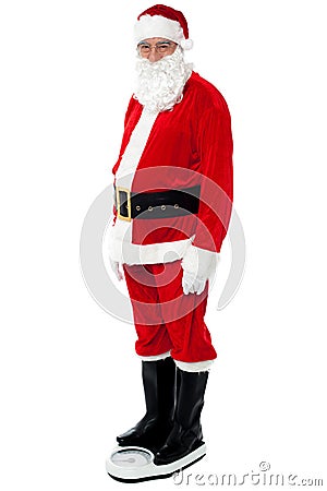 Health conscious Santa checking his weight Stock Photo