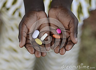 Health and Healthcare: Curing Malaria - African Girl Holding Pills Medicine Health Symbol. Stock Photo