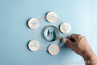 Health and Life insurance of protect family concept. Magnifier focus to family icon with healthcare medical icon on wooden cube Stock Photo