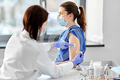 female doctor attaching patch to medical worker Stock Photo