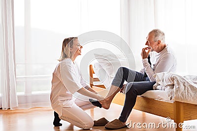 Health visitor and senior man during home visit. Stock Photo