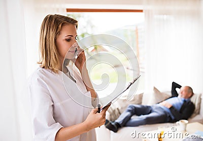 Health visitor and senior man during home visit. Stock Photo