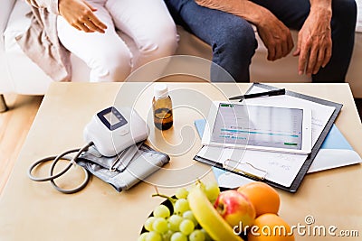 Health visitor and a senior man with tablet during home visit. Stock Photo