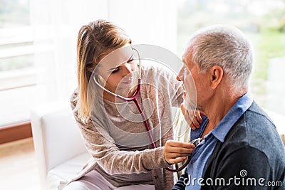 Health visitor and a senior man during home visit. Stock Photo