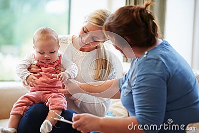 Health Visitor Talking To Mother With Young Baby Stock Photo